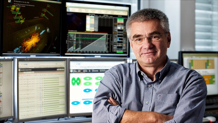 Photo showing Joachim Mnich in front of computer screens