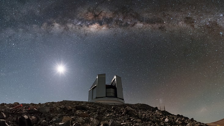 Teleskop mit geöffneter Kuppel auf einem Berg vor Nachthimmel